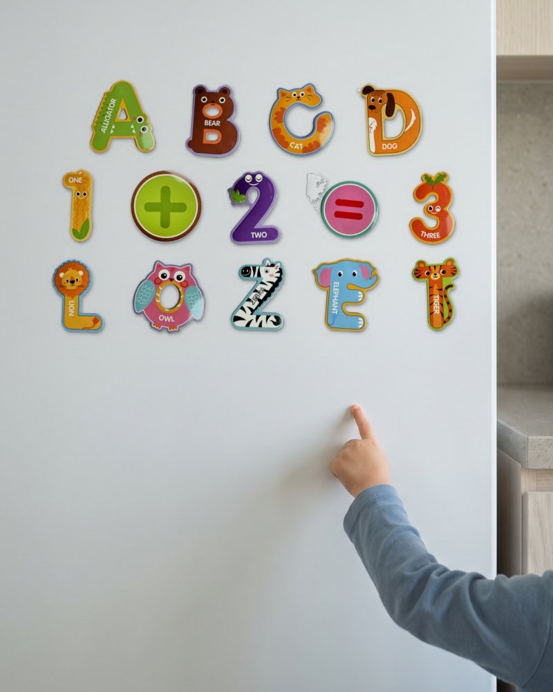 A child's hand placing a magnet on a white fridge door