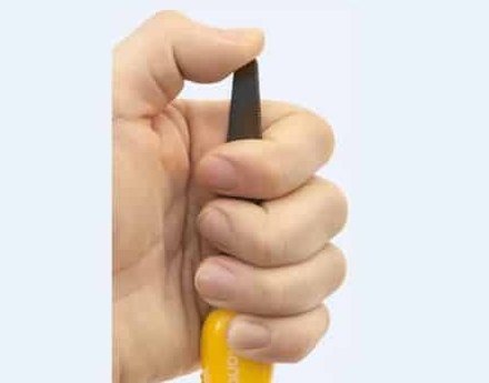 A hand holding the cutting tool by its rounded tip