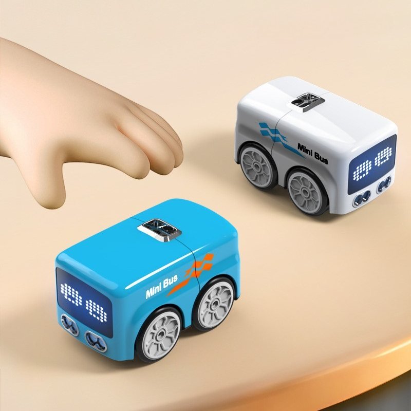 A hand next to two mini buses, showing how small they are