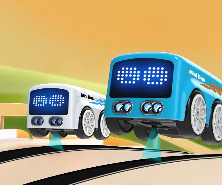 Two mini buses driving along a black line track
